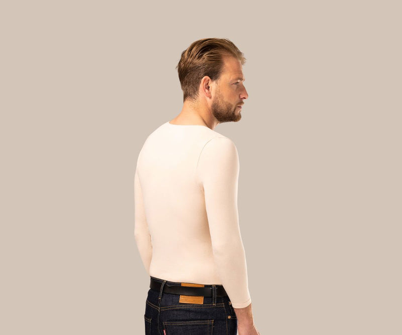 Man looking away wearing a mens nude undershirt with v-neck