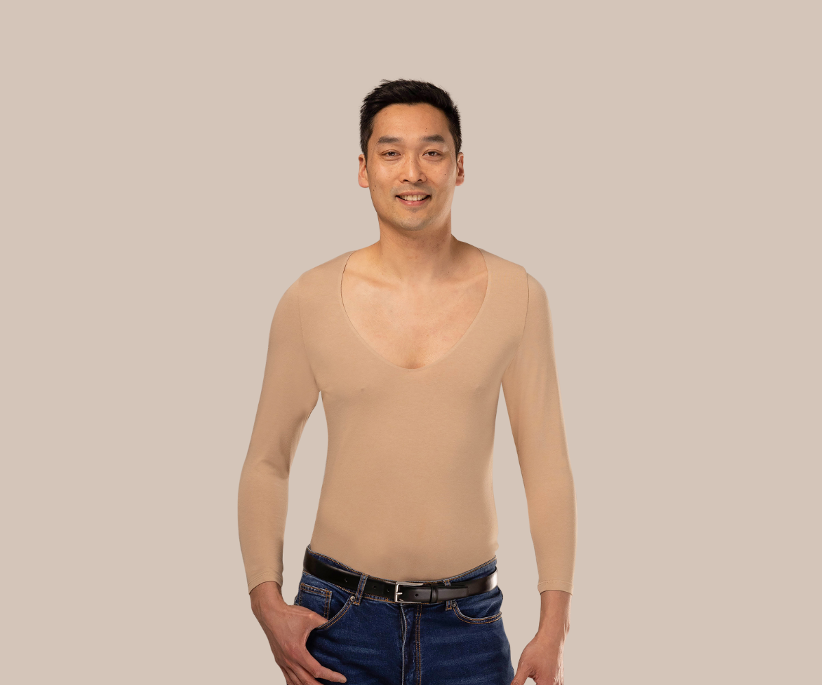 Man smiling wearing a beige mens undershirt tucked in